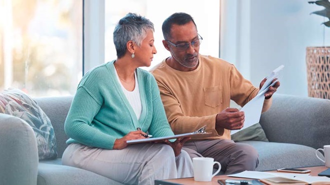 Filho e mãe, sentados no sofás tratam de documentos - alusão de documentos de heranças