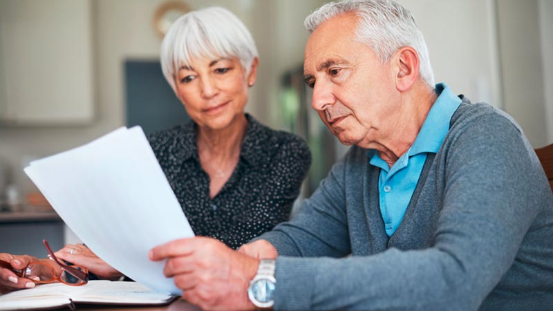 Casal sério sentado diante de um documento importante