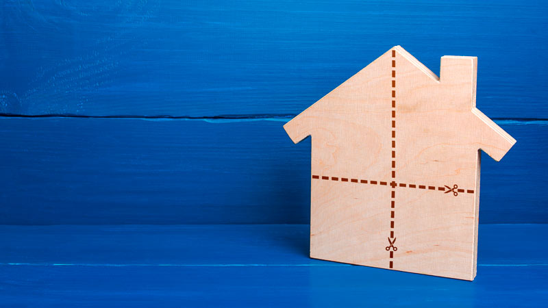 casa de madeira de brincar, plana, com riscos a dividi-la em quatro partes. Fundo de madeira azul