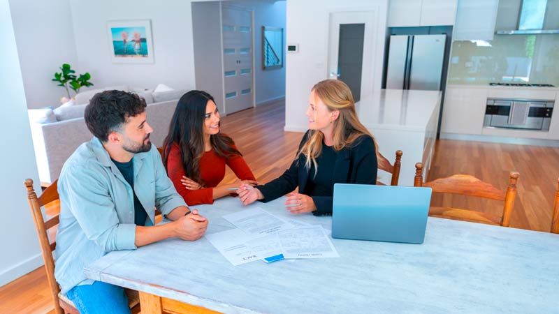 Senhorio sentado à mesa com inquilinos numa casa para arrendar