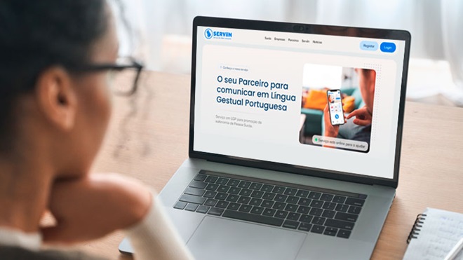 Grande plano de mulher a consultar um portátil com a plataforma Serviin no écran