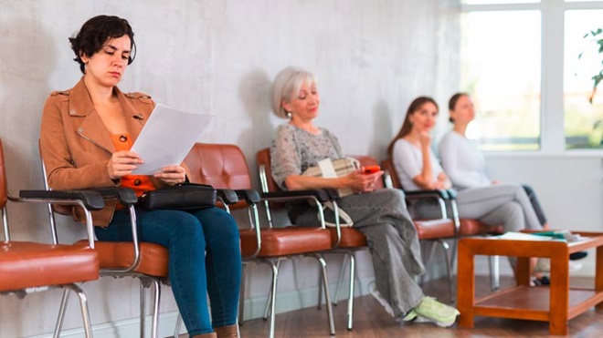 Pessoas sentadas a aguardar vez num serviço público