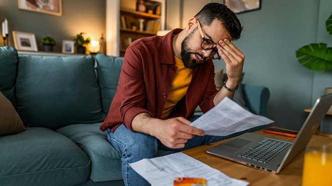 Homem preocupado a ver fatura