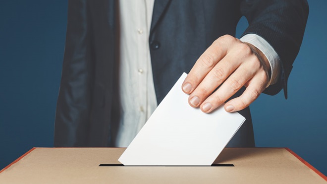pessoa a introduzir boletim de voto numa urna