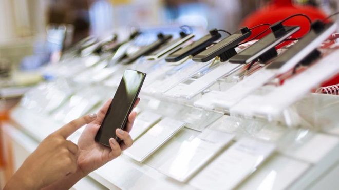 consumidor numa loja a ver telemóveis