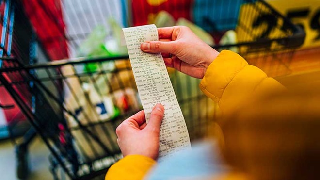 consumidor a analisar fatura do supermercado