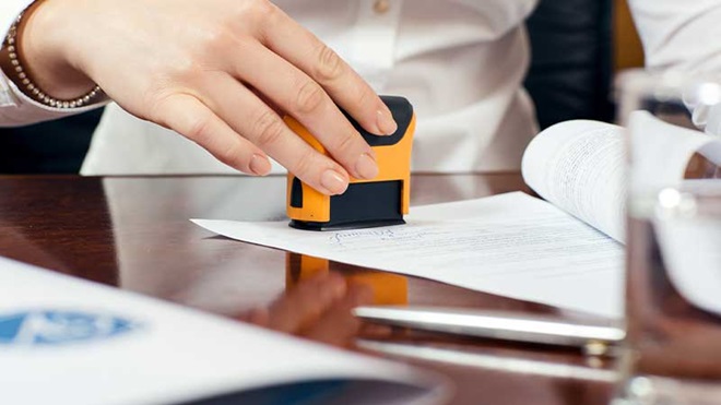 Mulher a carimbar documento