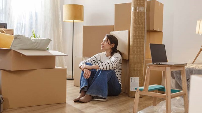 Jovem junto a caixotes de mudancas