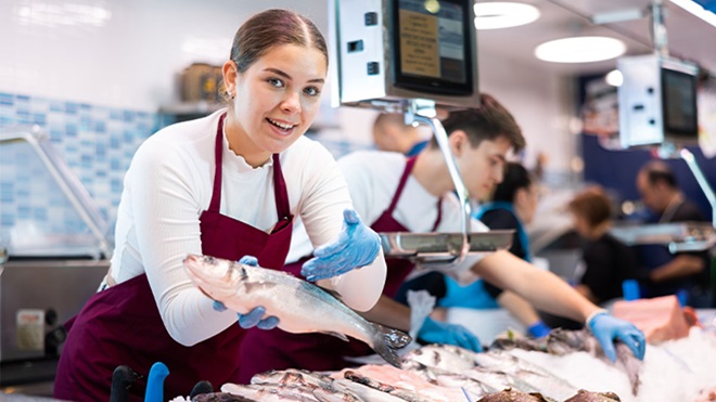 Peixeira a mostrar peixe a cliente
