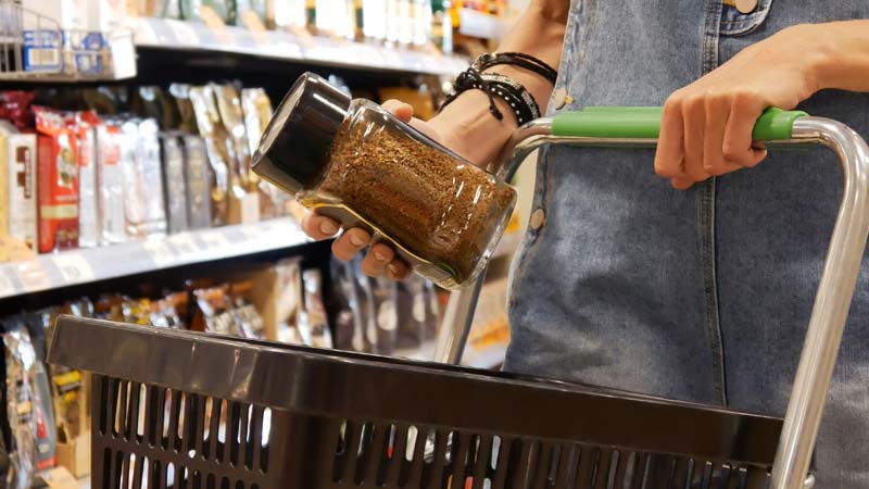 pessoa segura uma embalagem de café torrado moído no supermercado