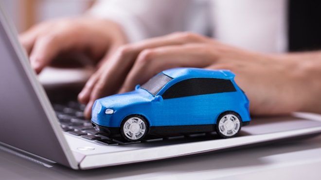 mulher com as mãos no teclado do computador, à procura de um simulador online de seguro automóvel