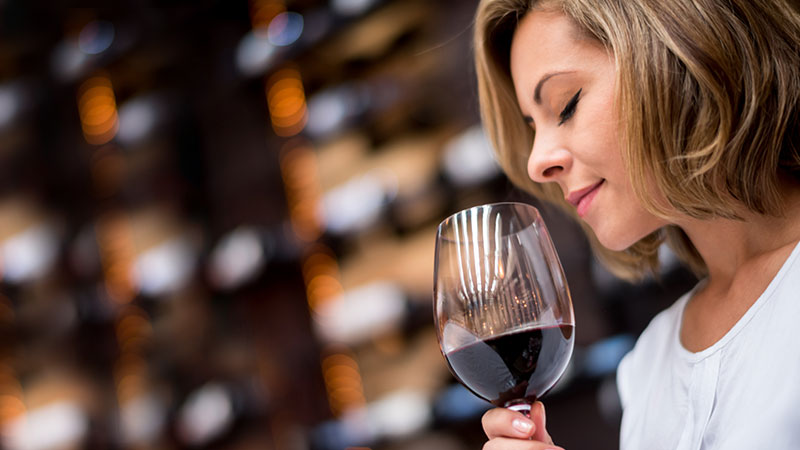 mulher a beber um copo de vinho tinto