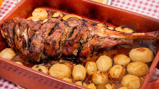Prato de cabrito com batatas e ramos de alecrim