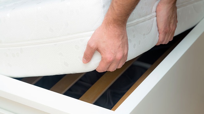 pessoa a levantar um colchão