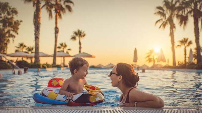 Mãe e filho na piscina ao pôr do sol