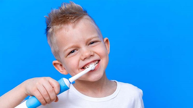 Criança a lavar os dentes com escove elétrica