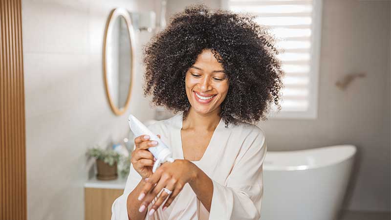 Mulher a colocar creme nas mãos