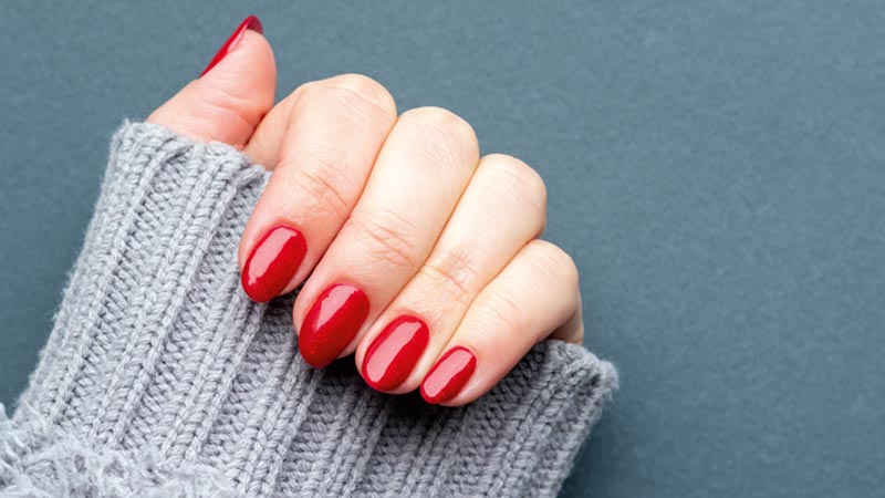 Mão de mulher com unhas pintadas de vermelho