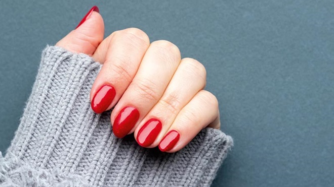 Mão de mulher com unhas pintadas de vermelho