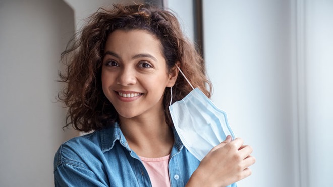 mulher a retirar a máscara