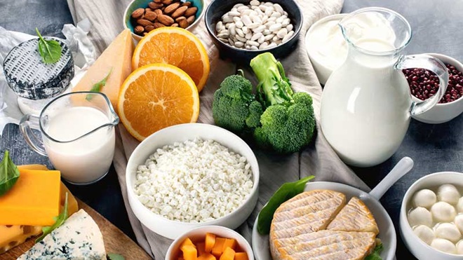 Mesa com leite, queijo, laranja, brócolos e sementes