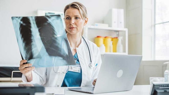Médica a observar radiografia aos pulmões