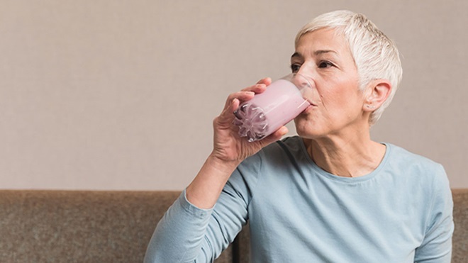 Mulher sénior a beber um batido