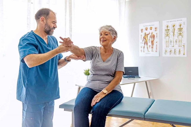 Mulher idosa em consultório com médico osteopata ou ortopedista