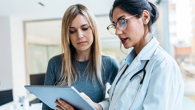 Mulher numa consulta com uma médica com ar sério