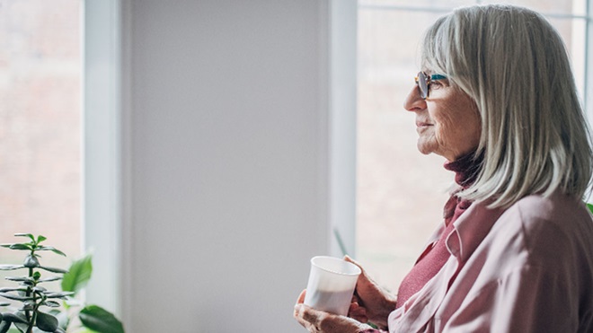 Mulher sénior bebe um suplemento num copo