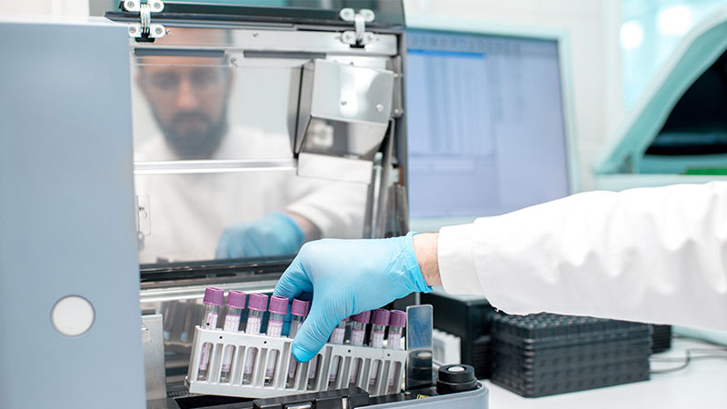 analista em laboratório a analisar amostras de sangue