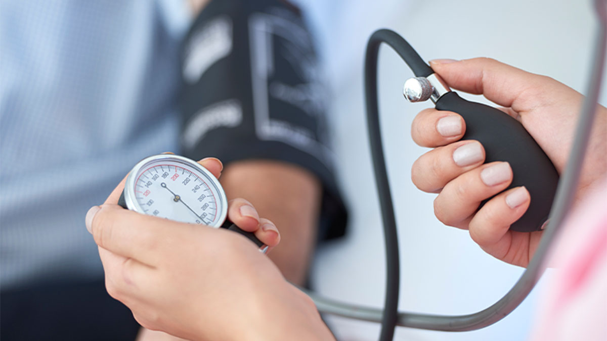 Médica a medir a tensão arterial a paciente