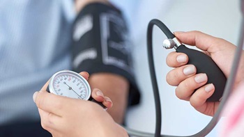 Médica a medir a pressão arterial a paciente