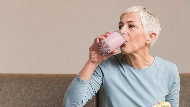 Melhor sénior de cabelo curto grisalho a beber um batido de reforço nutricional