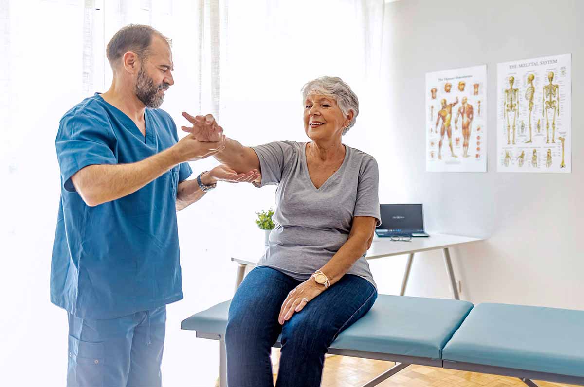 Mulher idosa em consultório com médico osteopata ou ortopedista