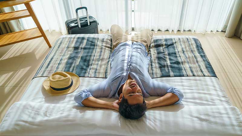 rapariga deitada num sofá de quarto de hotel