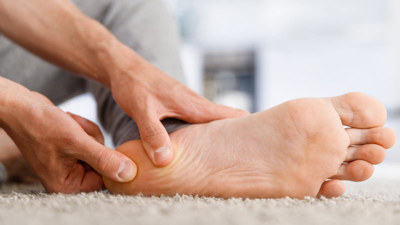 homem a pressionar a zona do calcanhar 