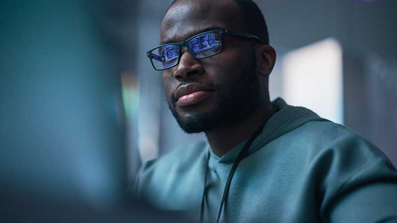 Homem de óculos a olhar para computador