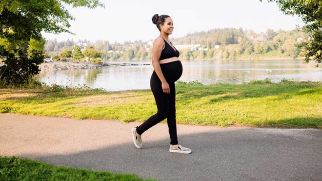 mulher grávida a caminhar