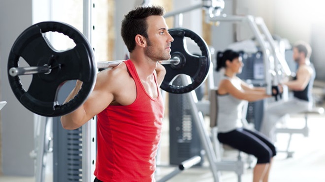 homem com pesos no ginásio