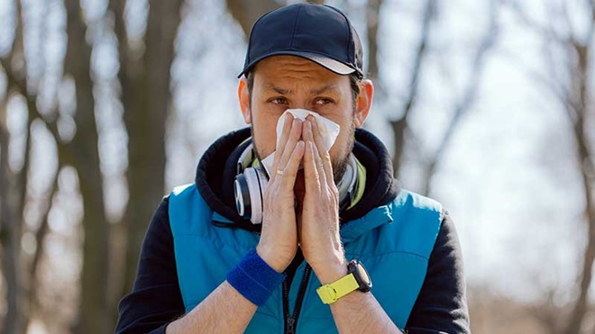Homem assoa-se durante o treino devido a alergia