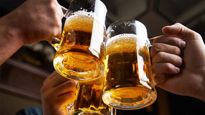 Grande plano de canecas de cerveja a brindar