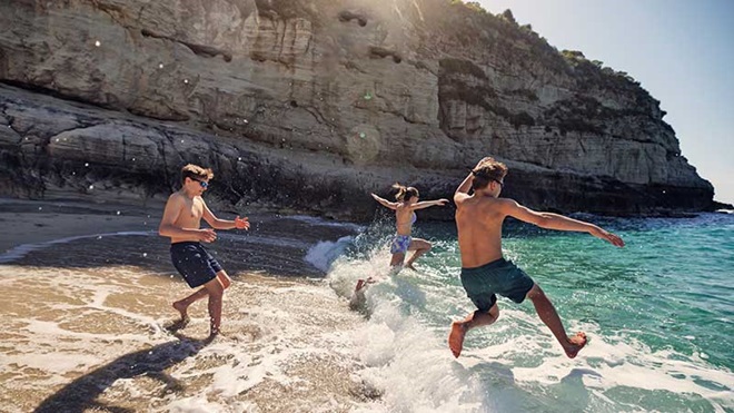 Jovens a tomarem banho na praia