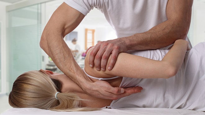 Terapeuta a endireitar as costas a uma paciente