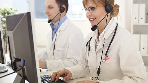 médicos a atender chamadas em frente ao computador