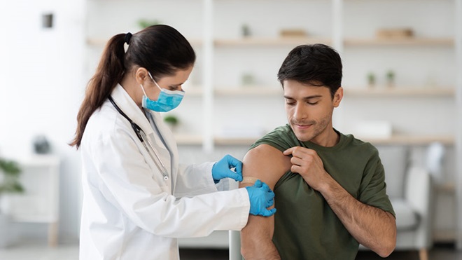 Adulto a levar uma vacina por um profissional de saúde