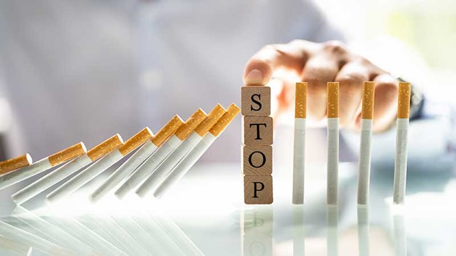 Cigarros a tombar e três cubos de madeira com a palavra stop