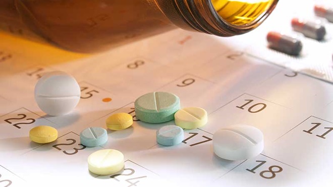 Comprimidos em cima de um calendário