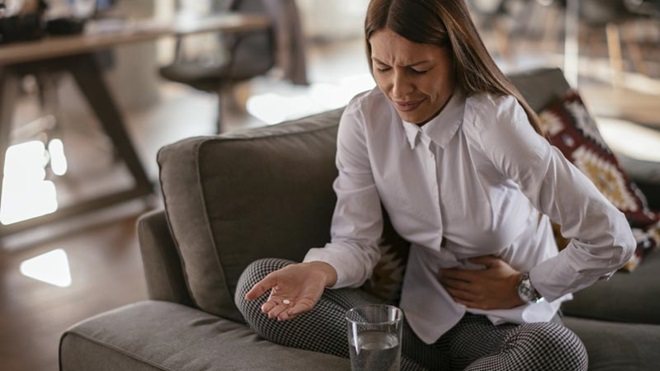 mulher a queixar-se com dores de estômago