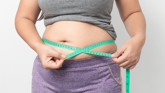 Mulher a medir perímetro abdominal com fita métrica
